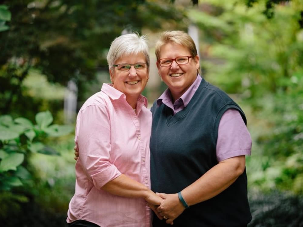 Female partners smiling following tax guidance on same-sex marriage
