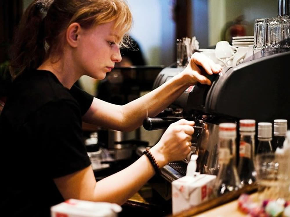 Young woman student employed as a barista for a sumemr job