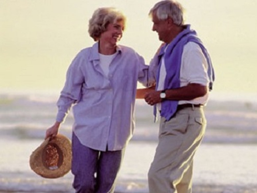 Happy retiree couple on beach are enjoying a successful retirement