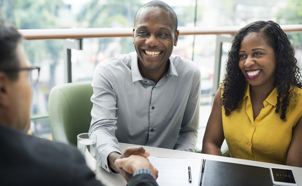 Young couple and financial planner discuss a list of important questions to ask a financial advisor