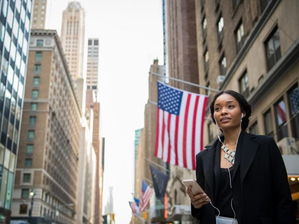 Young woman in Wall Street on the bull markets ninth anniversary