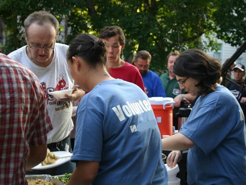 Volunteer line serving meals, giving sagely of their time and effort