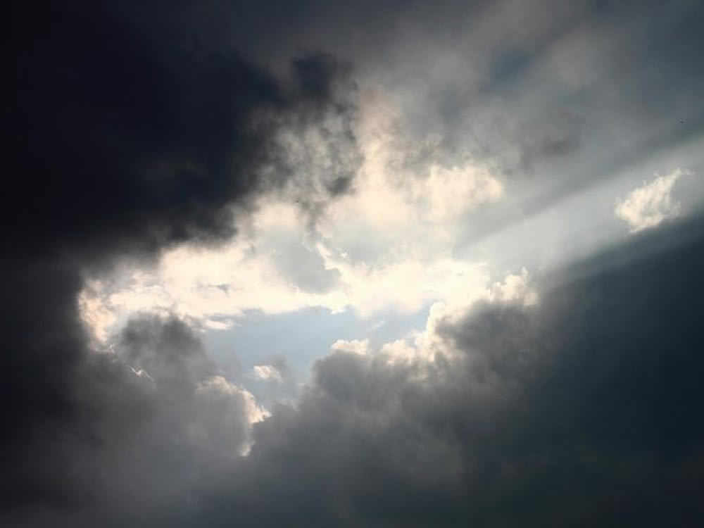 Sunbeams through clouds, symbolizing death of a family member