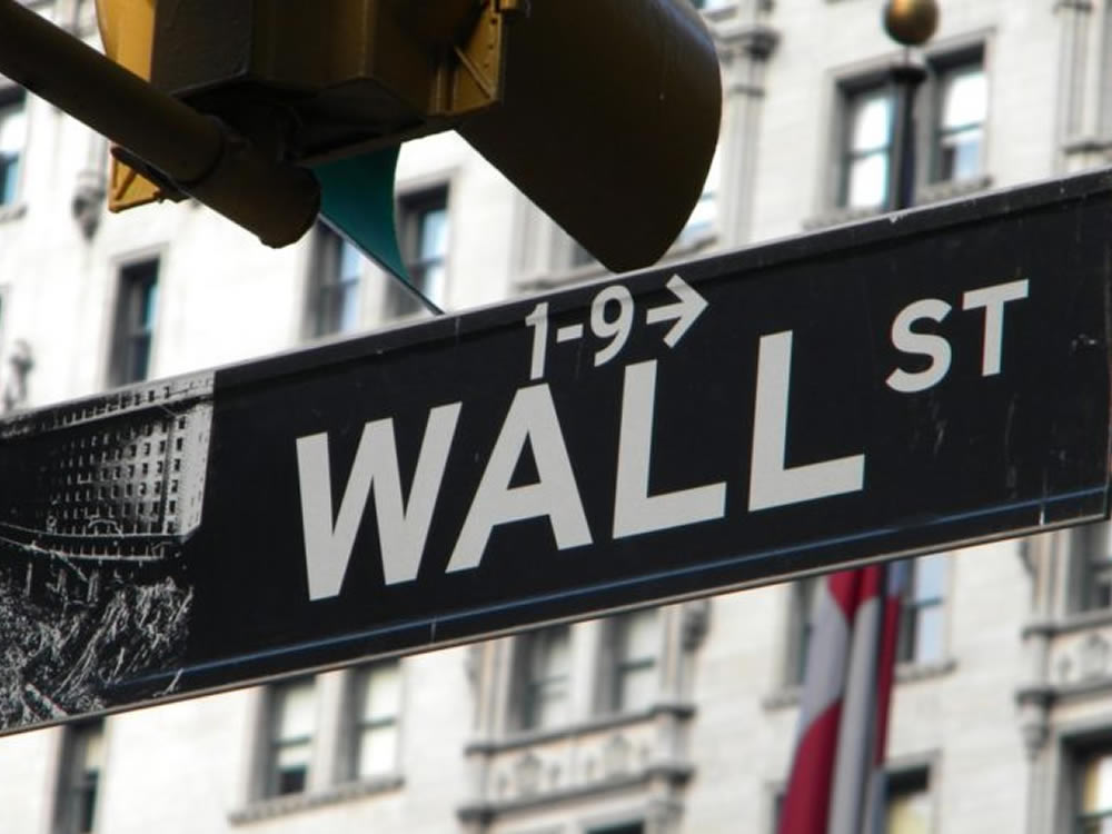 Wall Street sign showing the way to invest at market highs