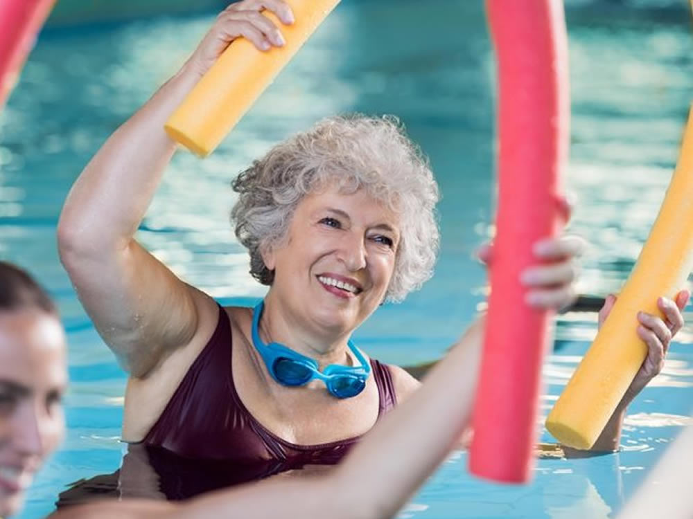 Senior woman doing water aerobics at retirement community