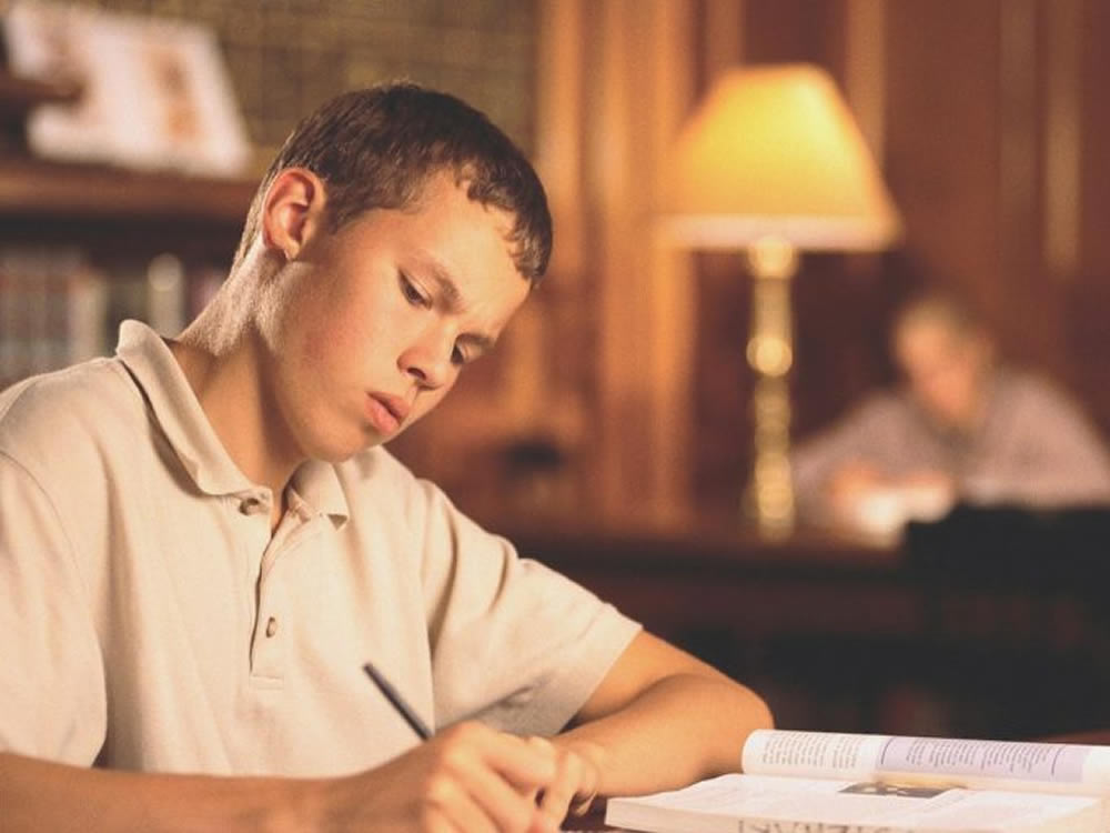 Male college student studying in library will benefit from campus banking updates