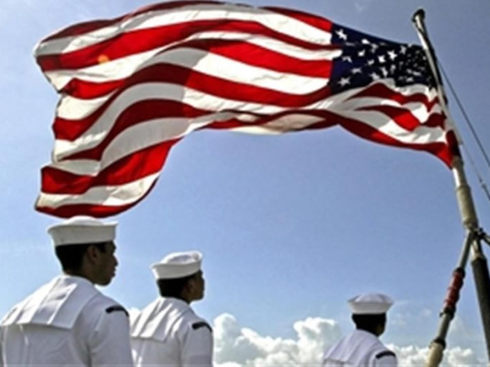 US sailors salute the flag in honor of military members