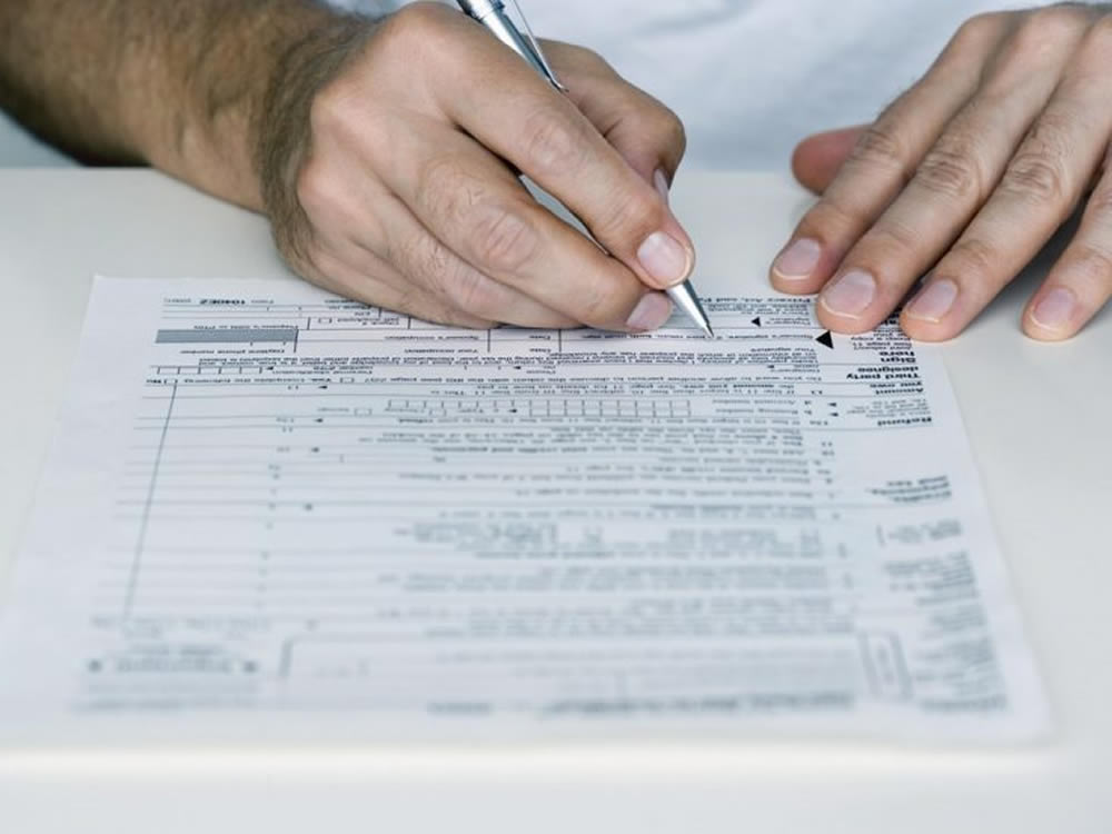 Man signing 1099 tax form considers what the tax reforms mean