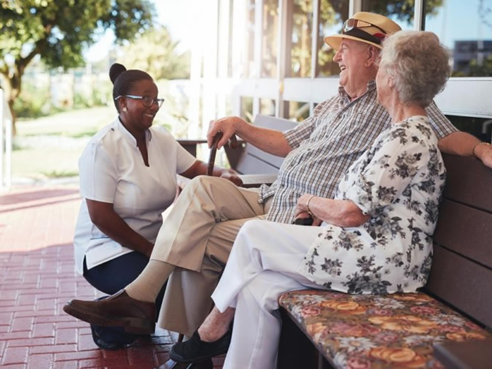 Nurse explains to elderly couple about long-term care insurance