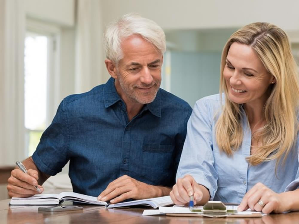 Happy couple check their finances with the SageVest Wealth Management quick review financial planning checklist