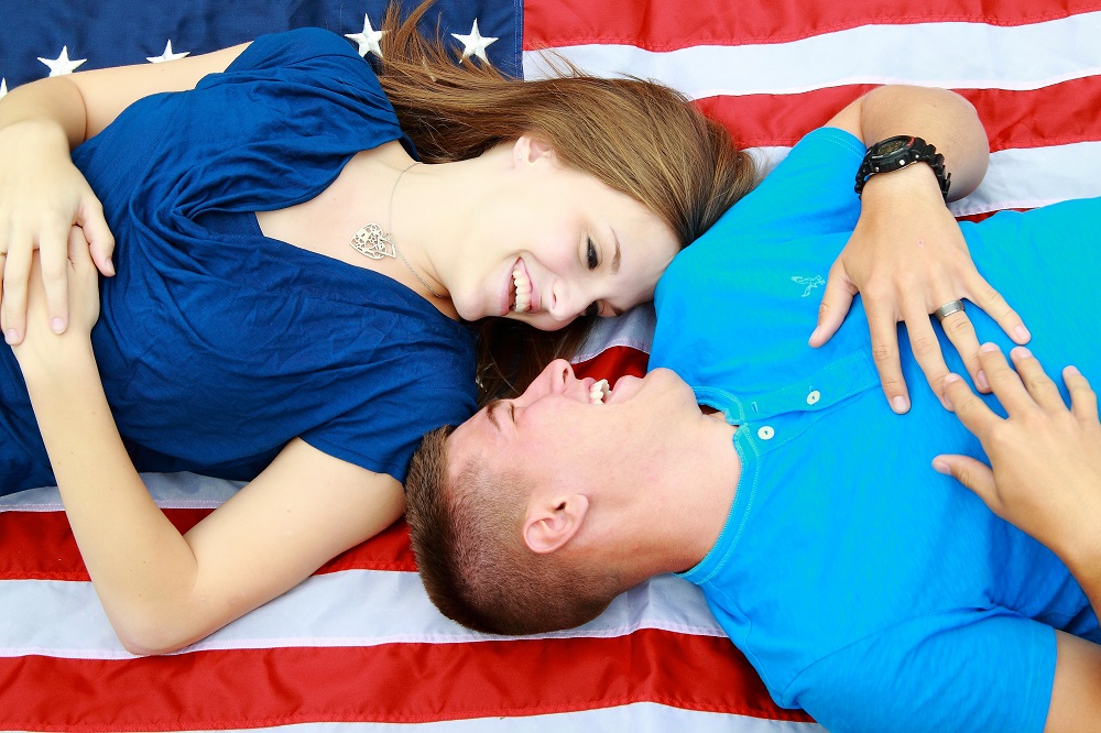 Young couple against US flag, representing financial independence