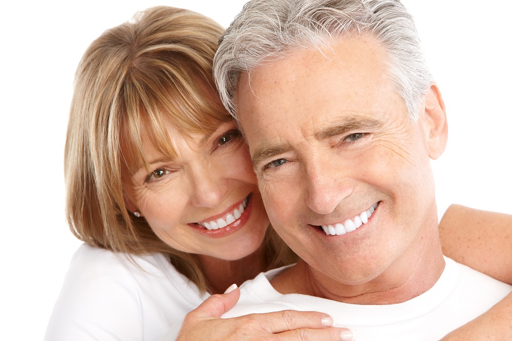 Older couple on white background, happy as they near retirement