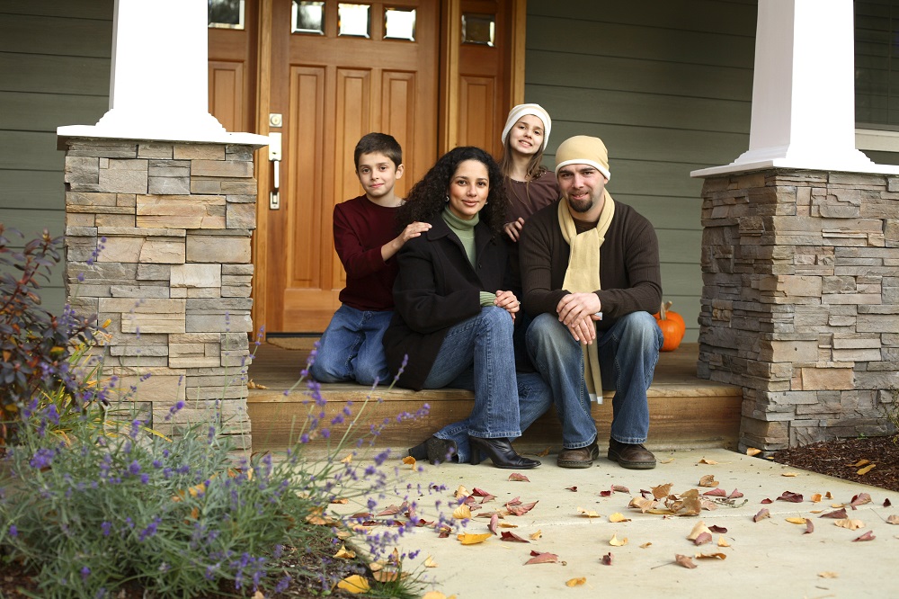 Blended family on porch of their new home in fall consider financial planning for blended families