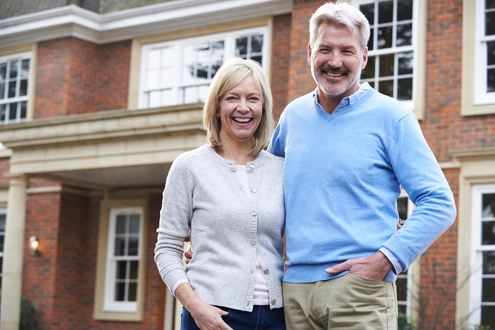 Couple standing outside home are happy they considered four good reasons to refinance now